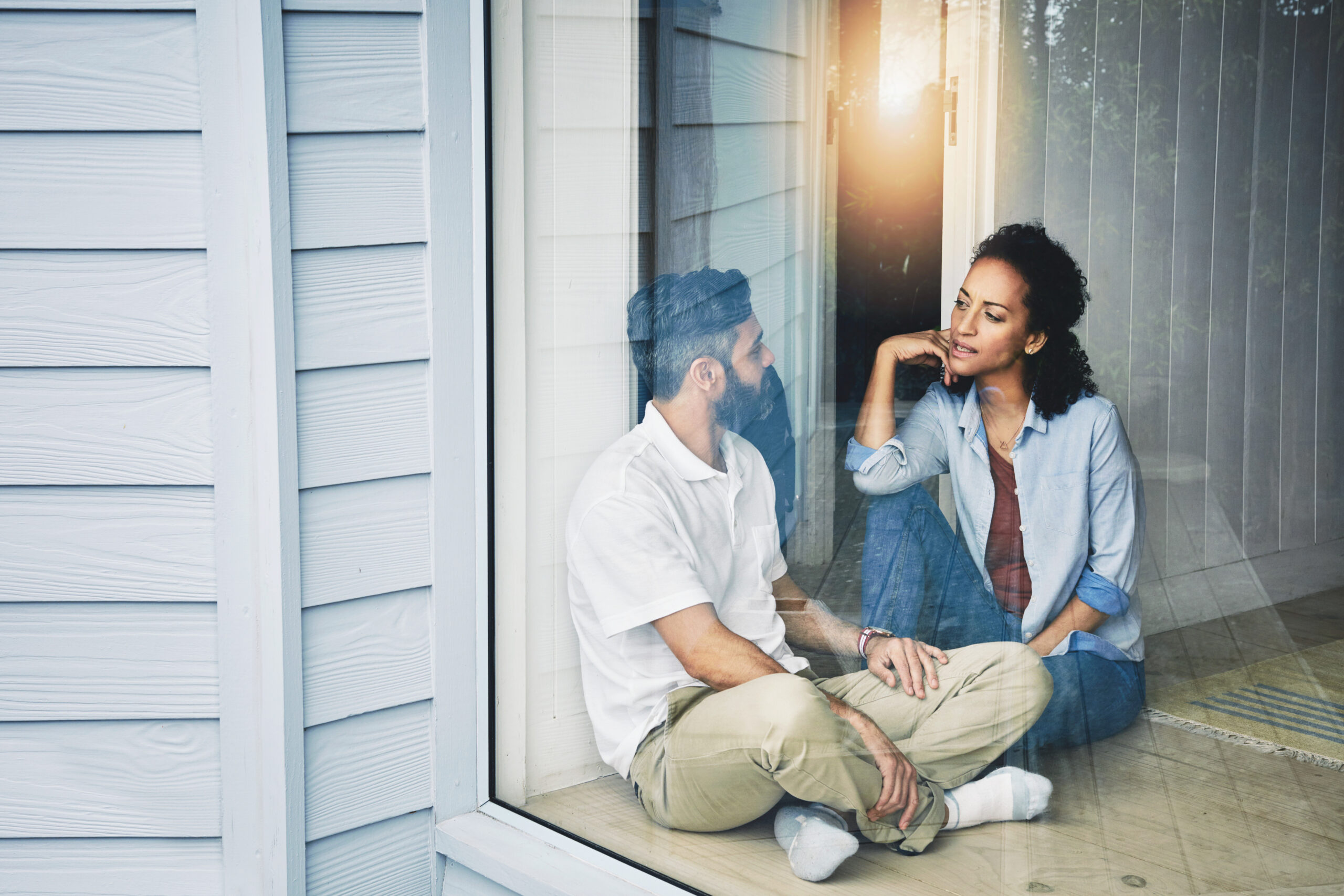 A diverse woman sitting and speaking to a diverse man