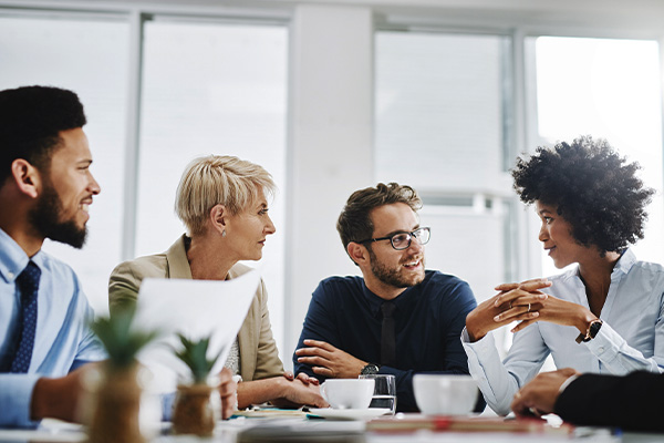 Diverse group of managers meet at a large table