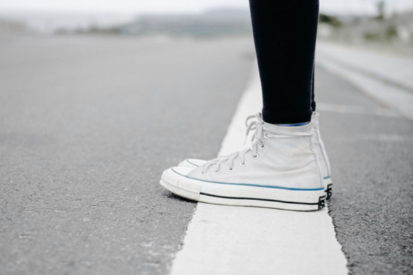 Person standing on a white line drawn on pavement