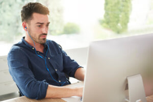 Man using his desktop computer for online learning
