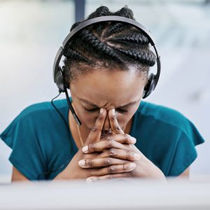 Black woman feeling overwhelmed holding her head in her hands