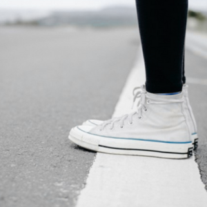 Person standing on a white line drawn on pavement