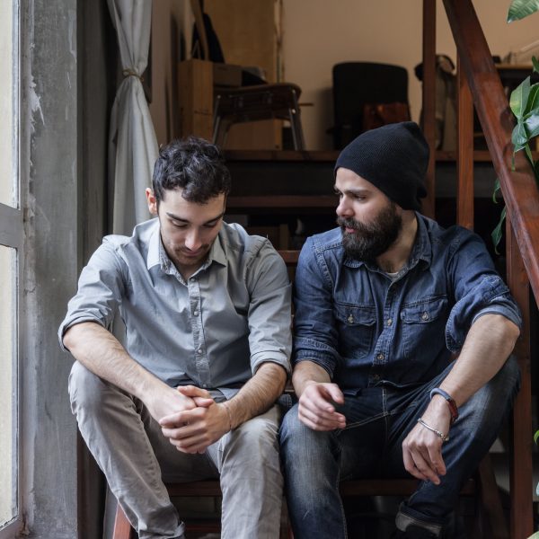 Couple of young men talking on the stairs of an office