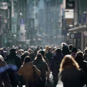 Crowd of people walking down a busy street